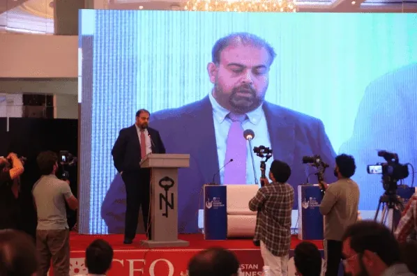 Speaker at the lectern with the media crew filming
